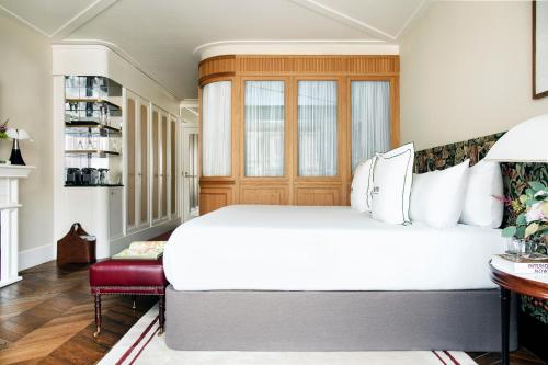 a bedroom with a large white bed and a red bench at BLESS Hotel Madrid - The Leading Hotels of the World in Madrid