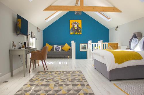 a bedroom with blue walls and a bed and a desk at Rainbow House - Entire Place in Lutterworth