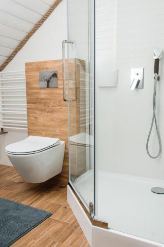 a bathroom with a glass shower and a toilet at Leśna Zagroda in Parchowo