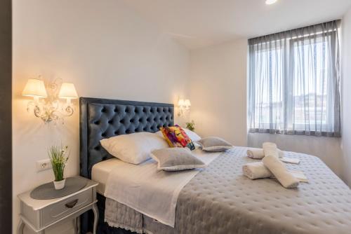 ein Schlafzimmer mit großem Bett und Fenster in der Unterkunft Carmen - Luxury 2-Bedroom Apartment - Downtown in Split