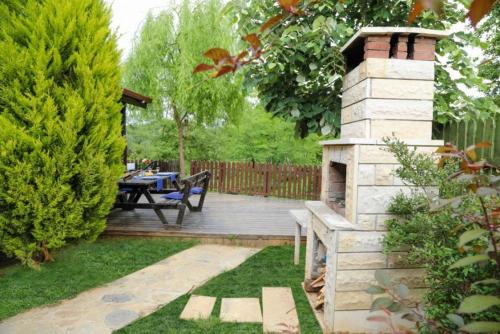 a wooden deck with a picnic table and a brick fireplace at Çınarhan Villas in Agva