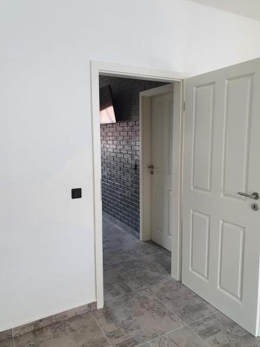 a hallway with a white door and a brick wall at Ferienwohnung am Kapellplatz in Altötting