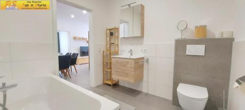 een badkamer met een bad, een toilet en een wastafel bij Apartment Marina by FiS - Fun in Styria in Bad Mitterndorf