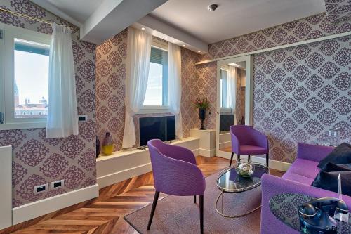 a living room with purple chairs and purple walls at Londra Palace Venezia in Venice