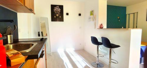 a kitchen with two blue stools in front of a sink at Citizenhouse - Gare in Valenciennes