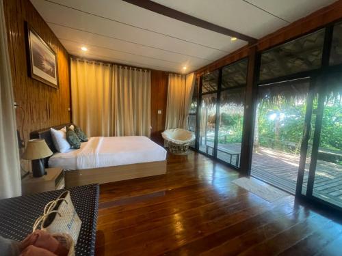 a bedroom with a bed and a balcony at บ้านริมเลปากประ Banrimlay Pakpra in Phatthalung