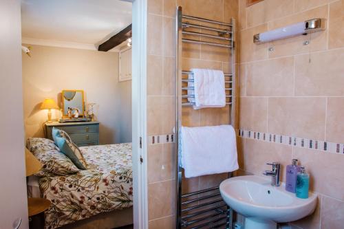 a bathroom with a shower and a sink and a bed at Whispering Place in the heart of Bewdley in Bewdley