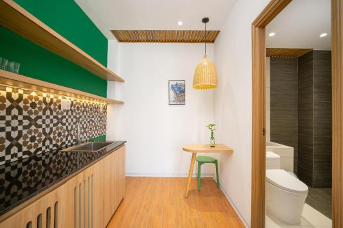 La salle de bains est pourvue d'un lavabo, de toilettes et d'une table. dans l'établissement Carol Villa Đà Nẵng Beach 1, à Đà Nẵng