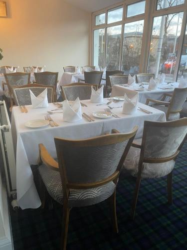 a row of tables and chairs with white table cloths at Grampian Hotel in Perth
