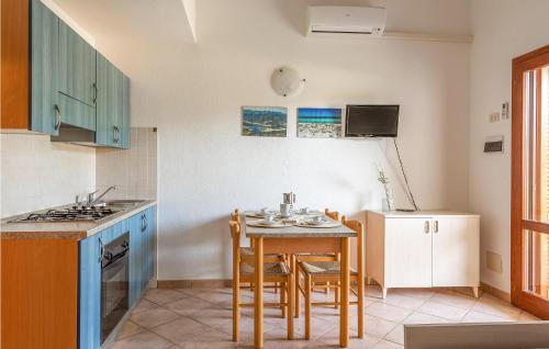 a kitchen with a table and chairs and a kitchen with a refrigerator at Trilo 6 in Budoni