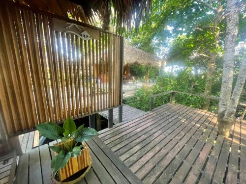 a wooden deck with a potted plant on it at บ้านริมเลปากประ Banrimlay Pakpra in Phatthalung