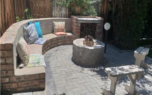 a patio with a couch and a fire pit at De Akker Guest House Oudtshoorn in Oudtshoorn