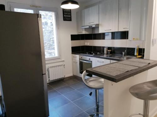 une cuisine avec des armoires blanches et un comptoir dans l'établissement Eden Host, à Clermont-Ferrand