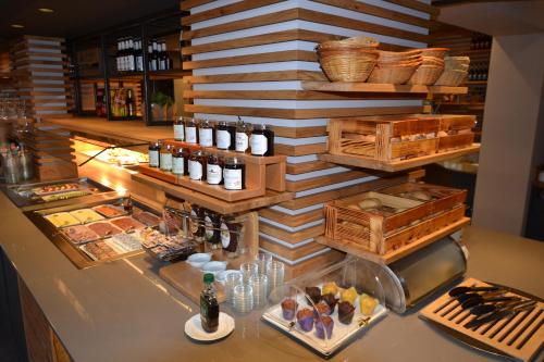 a restaurant with a counter with food and drinks at Hotel Bockelmann in Bispingen