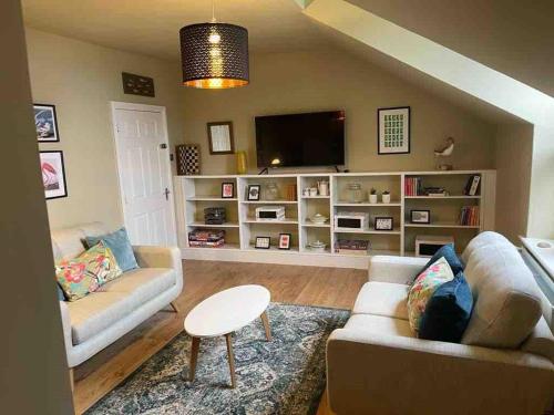 a living room with a couch and a tv at Keeper's Rest in Cromer