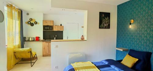 un salon avec un canapé bleu et une cuisine dans l'établissement Citizenhouse - Gare, à Valenciennes