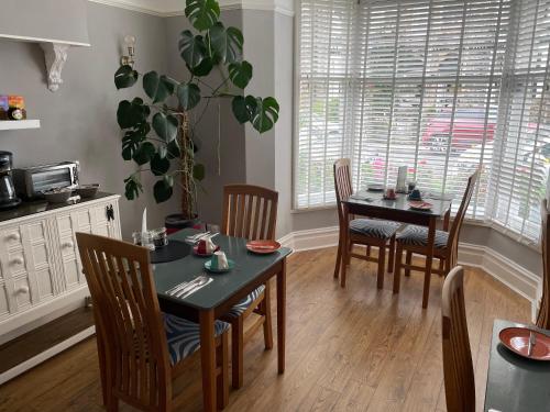 ケズウィックにあるGlendale Guest Houseのダイニングルーム(テーブル、椅子、植物付)