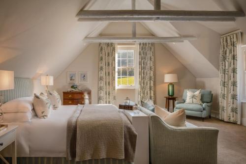 ein Schlafzimmer mit einem Bett, einem Stuhl und einem Fenster in der Unterkunft Brookdale Estate - Manor House in Paarl