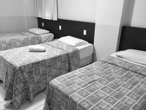 a hotel room with three beds in it at JB Hotel in Petrolina