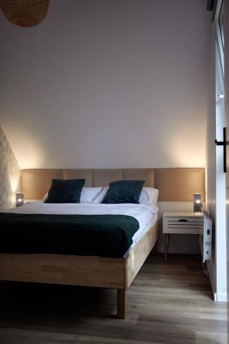 a bedroom with a large bed with a wooden headboard at Osada Hygge in Gostynin