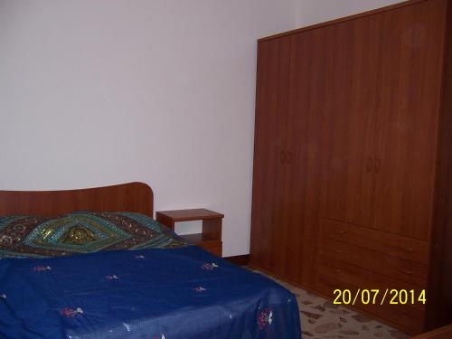 a bedroom with a bed and a wooden dresser at Ni La Za Ciccina in Castellammare del Golfo
