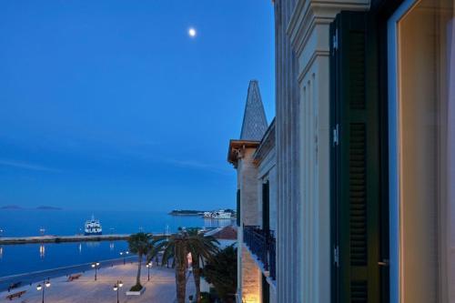 a large building with a clock on the side of it at Poseidonion Grand Hotel in Spetses