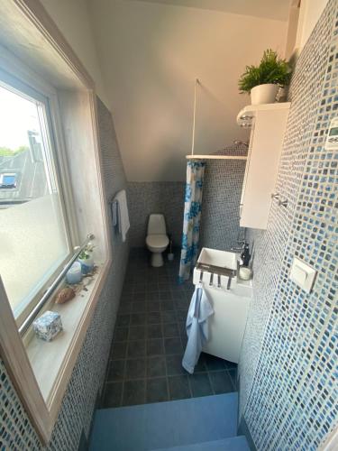 a bathroom with a tub and a toilet and a sink at Hotell Villa Borgen in Visby