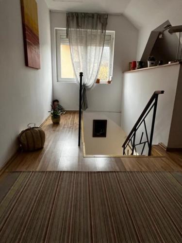 a living room with a staircase and a window at House of Julia in Sighişoara