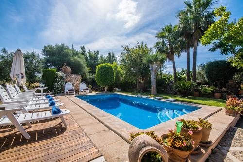 una piscina con terrazza, sedie e alberi di Ideal Property Mallorca - Villa Erika a Inca