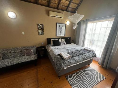a bedroom with a large bed and a window at Mopani Villa in Marloth Park