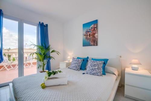 ein Schlafzimmer mit einem großen Bett mit blauen Akzenten in der Unterkunft Ideal Property Mallorca - Son Moleto in Sa Ràpita