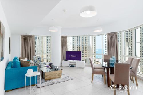 a living room with a blue couch and a table at Dream Inn Apartments - Al Sahab in Dubai