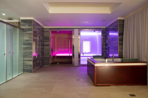 a bathroom with a sink and purple lighting at Wellness Santa Hotel - adults plus12 in Agia Triada