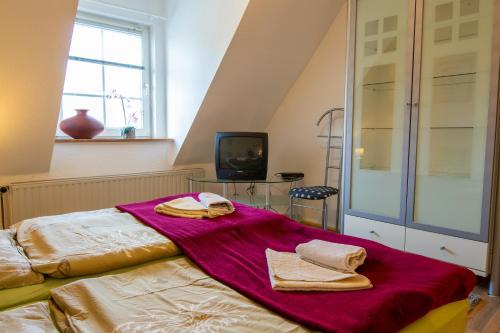 a bedroom with a bed with towels on it at Pension bei Stralsund in Prohn