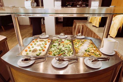 a buffet with two trays of food on a table at Hotel Kudowa Manufaktura Relaksu in Kudowa-Zdrój