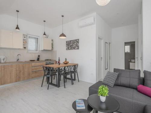 ein Wohnzimmer mit Couch und Tisch und eine Küche in der Unterkunft Apartment Dolce in Cavtat