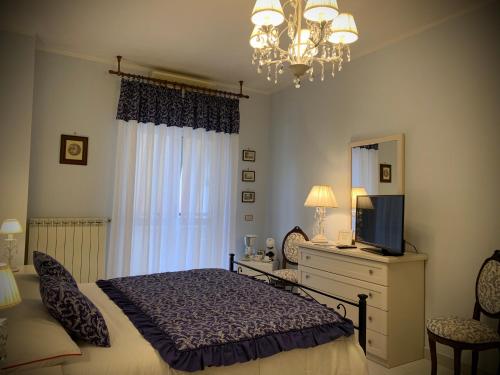 1 dormitorio con cama, espejo y lámpara de araña en Al civico 28, en Santa Marinella