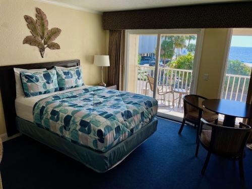 a hotel room with a bed and a balcony at 2 Bed Condo with Balcony Facing Pool and Sunsets! in Tampa