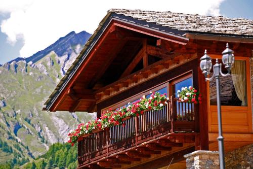 un balcón con flores y una montaña en Les Combes en La Salle