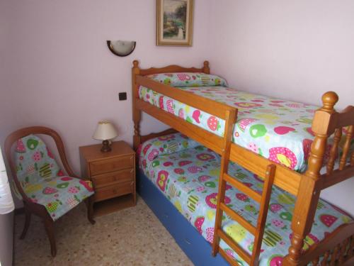 a bedroom with a bunk bed and a chair at Apartamento Fanals in Lloret de Mar