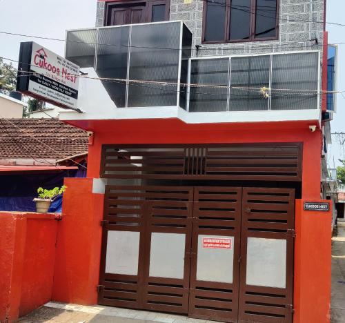 an orange building with two garage doors on a street at Cukoos Nest in Cochin