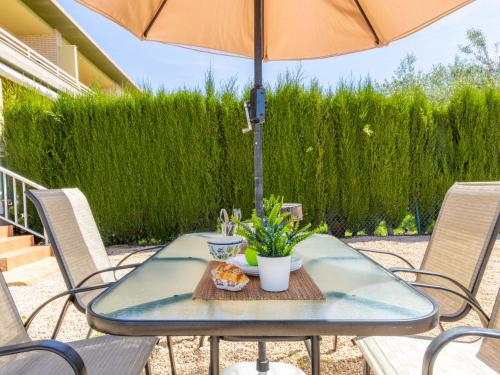 a table with an umbrella on a patio at Holiday Home Mestral by Interhome in L'Ampolla