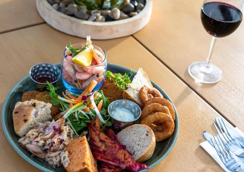 a plate of food on a table with a glass of wine at Kingscliff, BW Signature Collection in Clacton-on-Sea