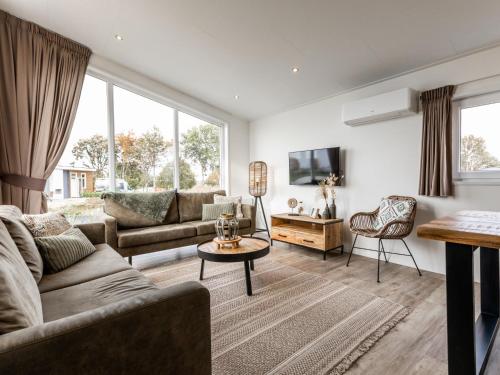 a living room with a couch and a table at Holiday Home Green Resort Mooi Bemelen-1 by Interhome in Bemelen