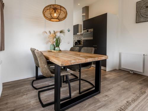 a dining room with a wooden table and chairs at Holiday Home Green Resort Mooi Bemelen-1 by Interhome in Bemelen
