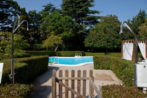 a swimming pool in a garden with a fence at Hotel Rio Bidasoa in Hondarribia