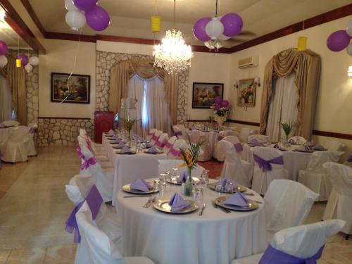a banquet hall with white tables and purple decorations at Rayon Hotel in Negril