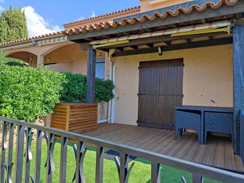 une terrasse en bois avec une table sur une maison dans l'établissement Vue panoramique exceptionnelle, au Lavandou