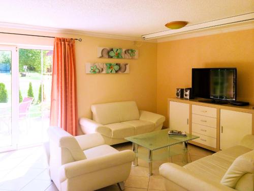 ein Wohnzimmer mit einem Sofa und einem TV in der Unterkunft Holiday Home Ferienpark Verchen-1 by Interhome in Verchen