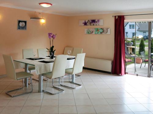 ein Esszimmer mit einem Tisch und weißen Stühlen in der Unterkunft Holiday Home Ferienpark Verchen-1 by Interhome in Verchen